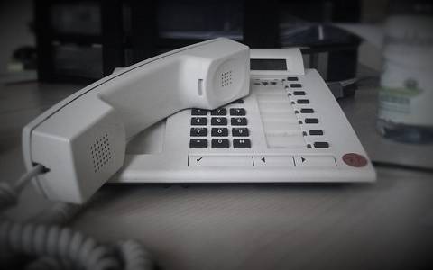 Telefonhörer neben Telefon abgelegt.