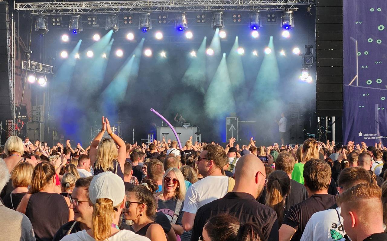 Menschen stehen vor einer Bühne.