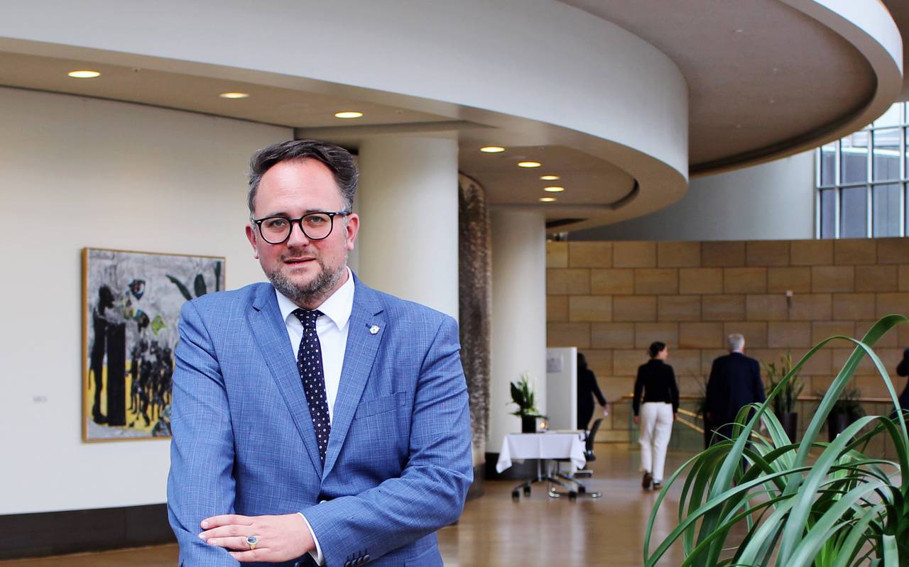 Matthias Eggers steht im mittelblauen Anzug an einem hölzernen Geländer.