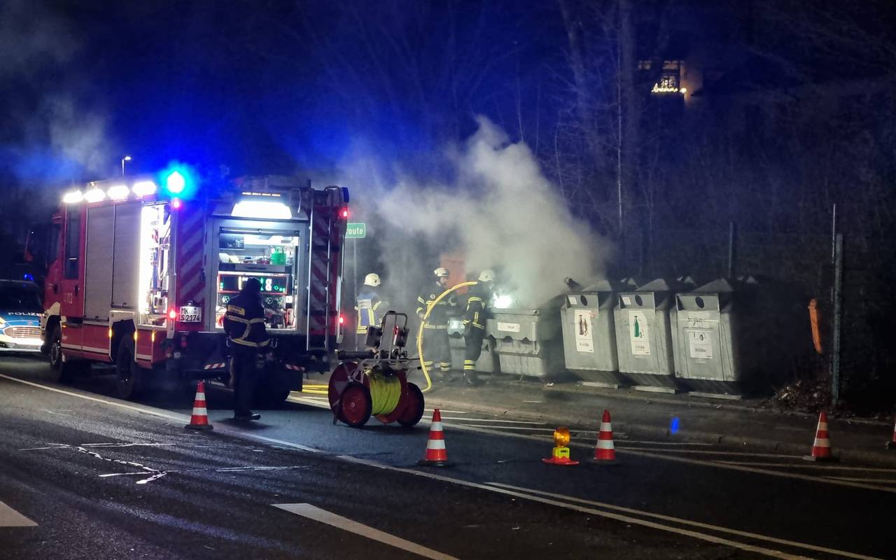 Die Feuerwehr löscht einen brennenden Altpapiercontainer.