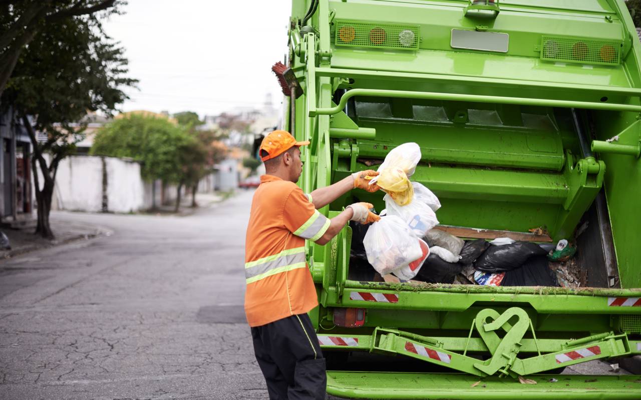 Mann sammelt Müll für Müllabfuhr ein