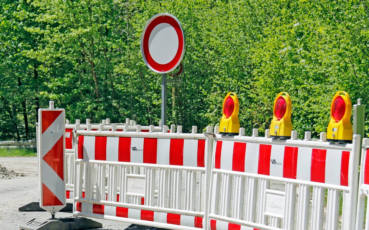 Baustellenabsperrungen vor einer Straße.
