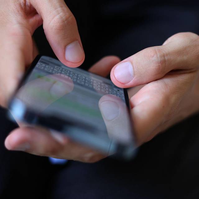 Mann tippt auf einem Smartphone eine WhatsApp Nachricht
