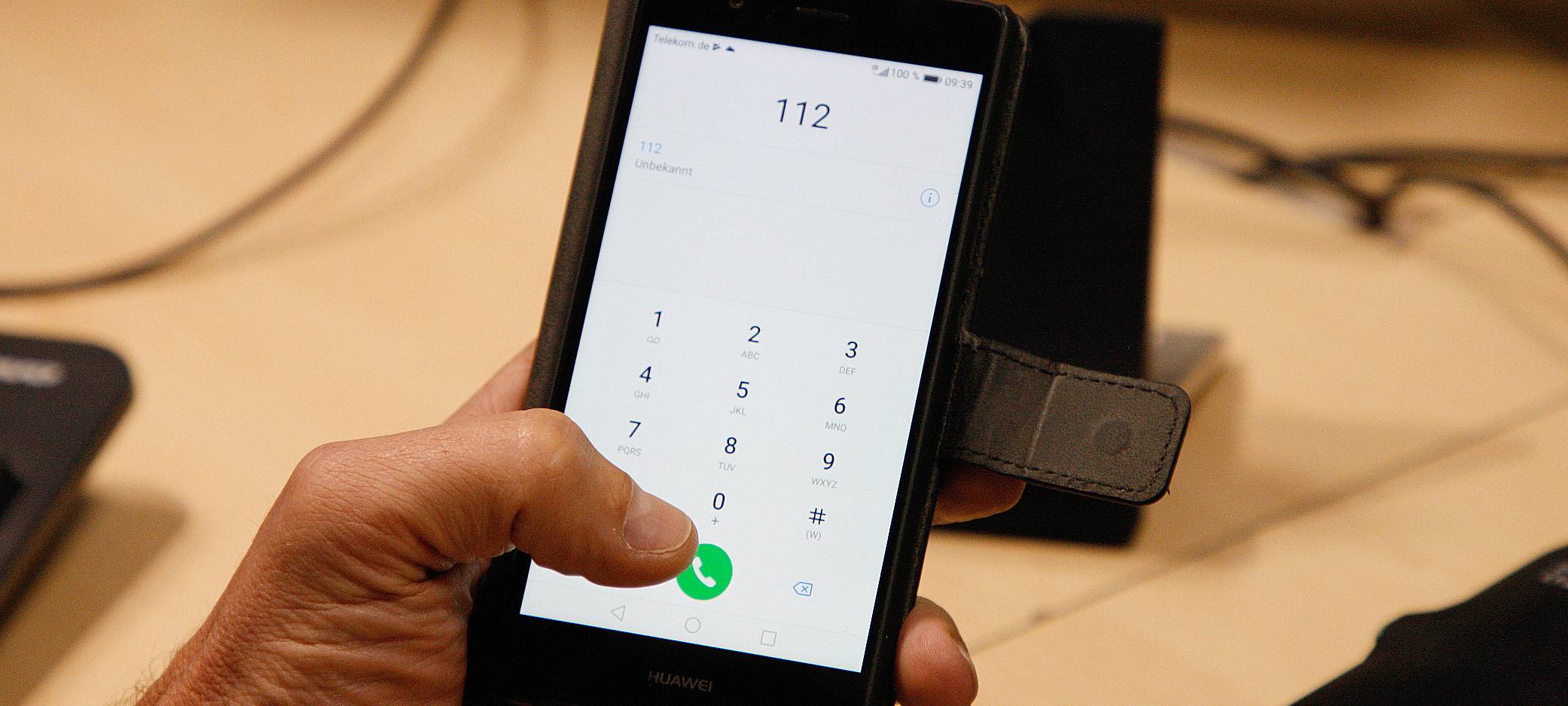 Eine Person wählt auf dem Handy die 112. Wir sehen das Display des Handys.