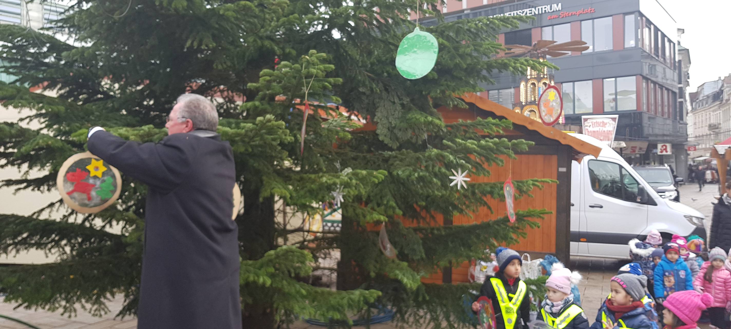 Kinder schmücken Weihnachtsbaum auf dem Sternplatz