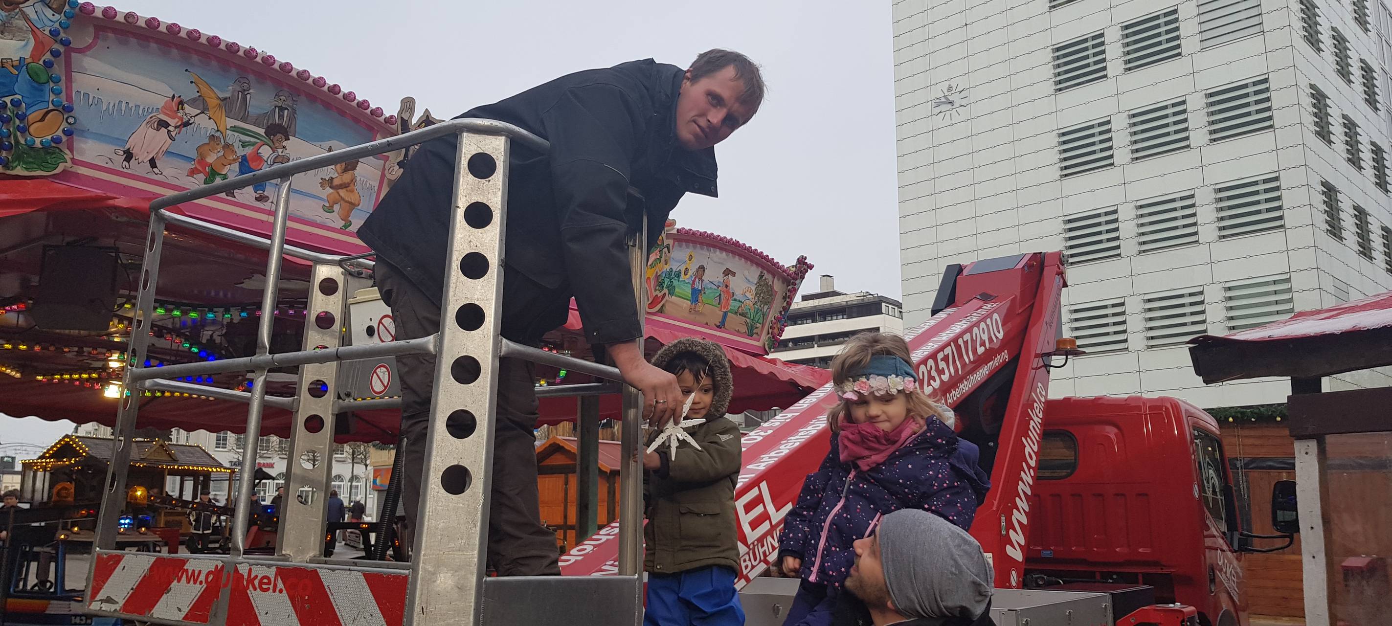 Kinder schmücken Weihnachtsbaum auf dem Sternplatz