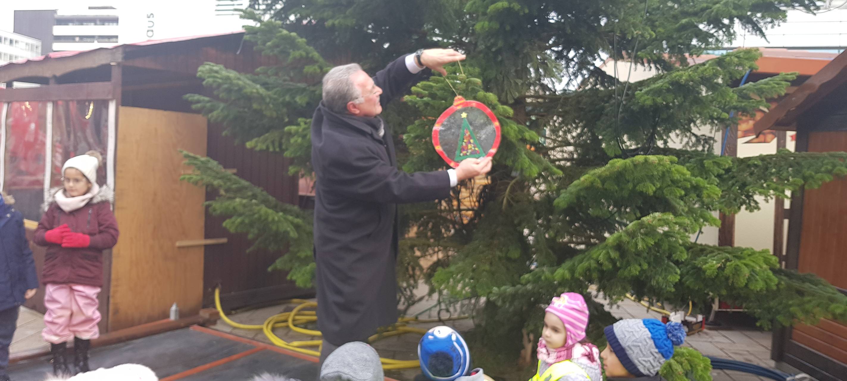 Kinder schmücken Weihnachtsbaum auf dem Sternplatz