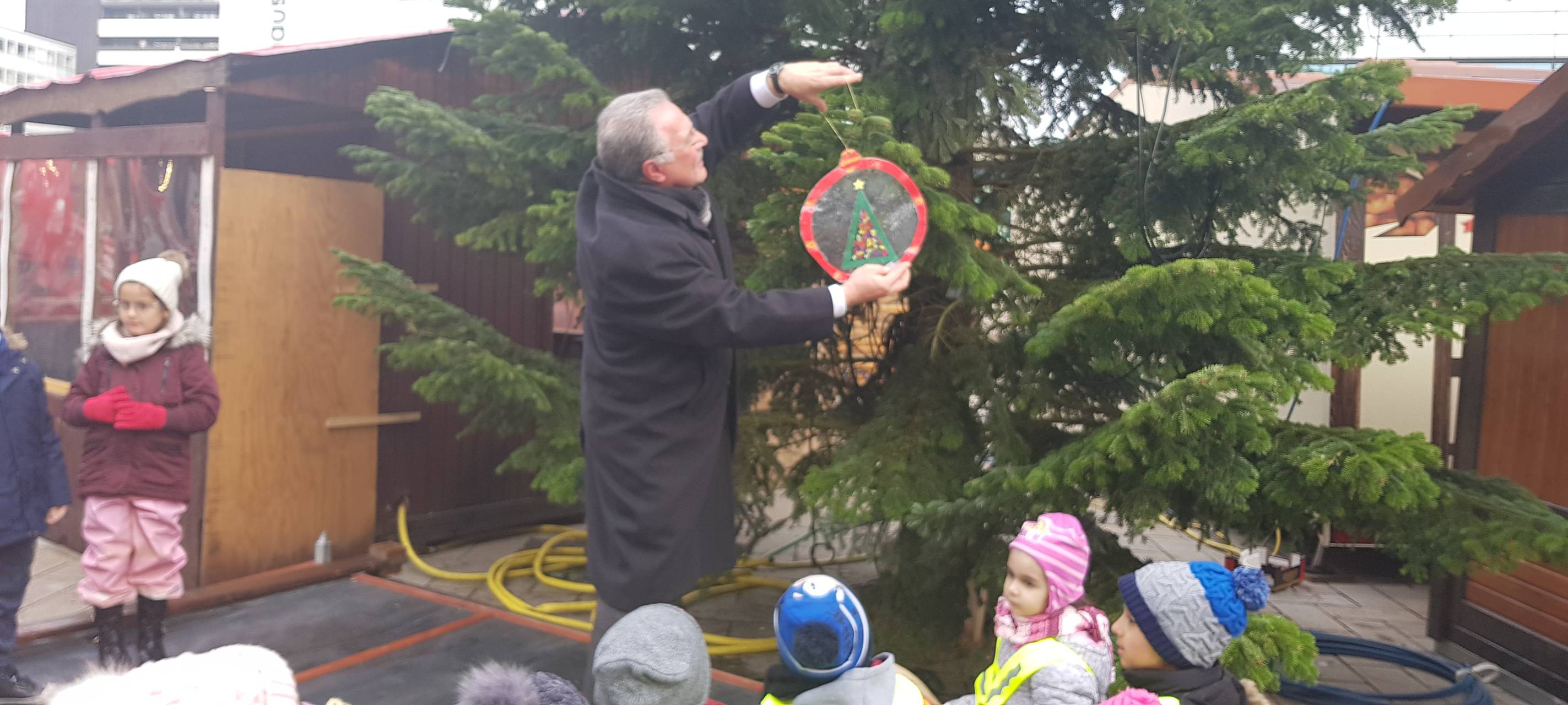 Kinder schmücken Weihnachtsbaum auf dem Sternplatz