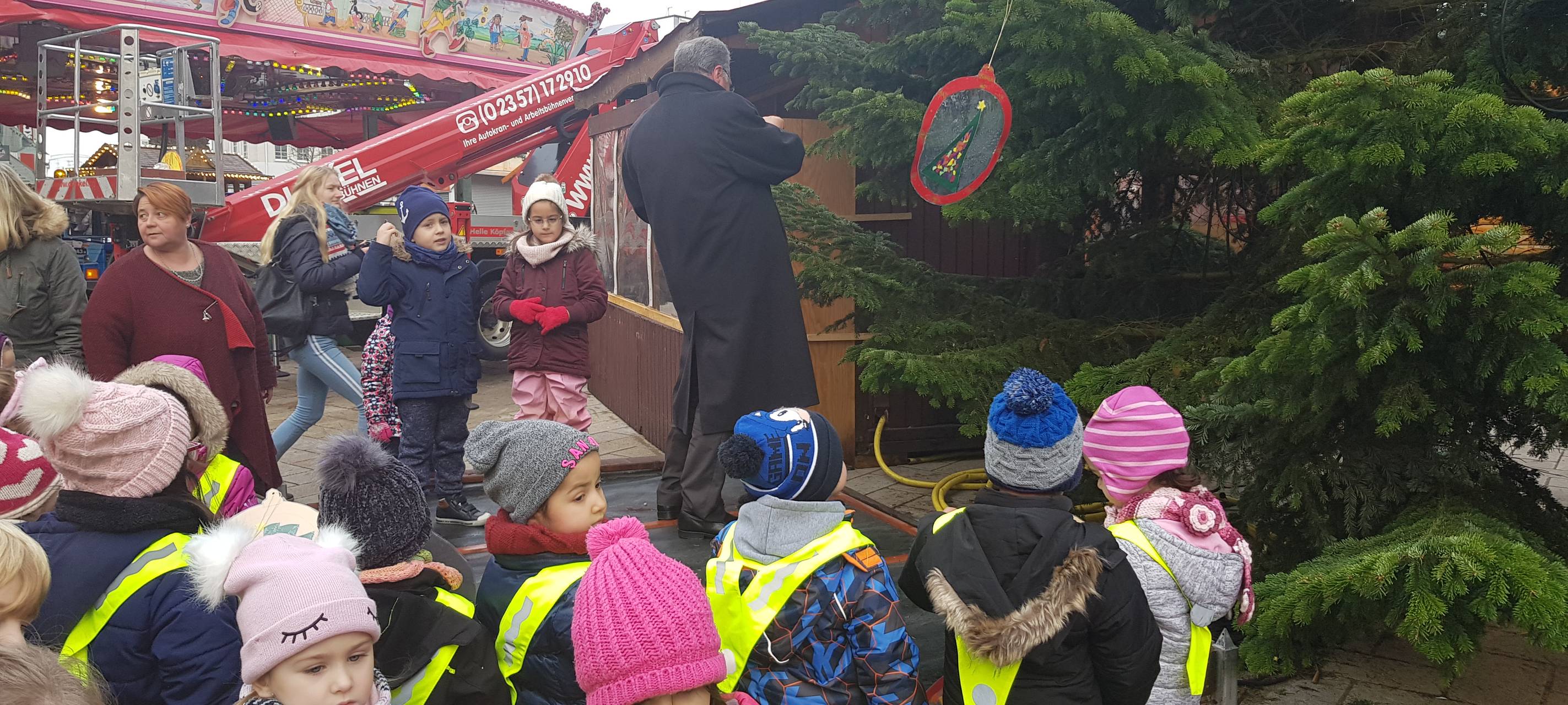 Kinder schmücken Weihnachtsbaum auf dem Sternplatz