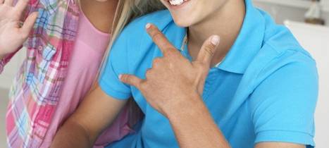 Eine Frau und ein Jugendlicher schauen gemeinsam auf einen Laptop.