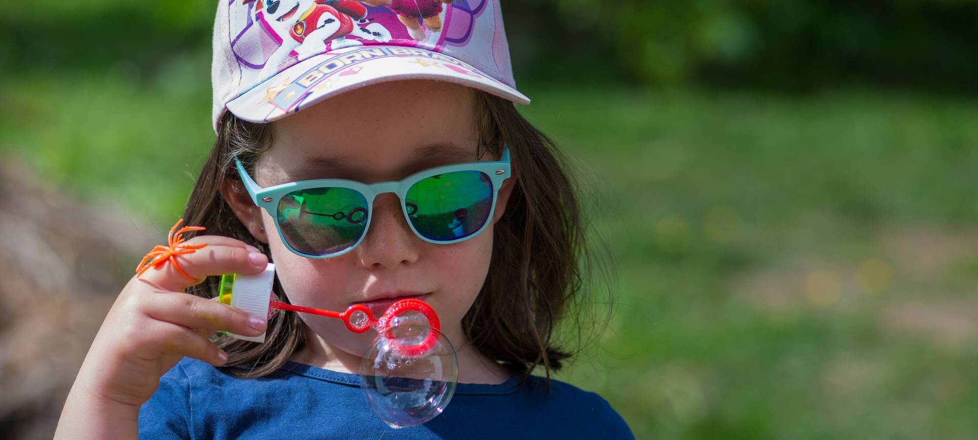 Kleinkind im Sommer mit Cap und Sonnenbrille