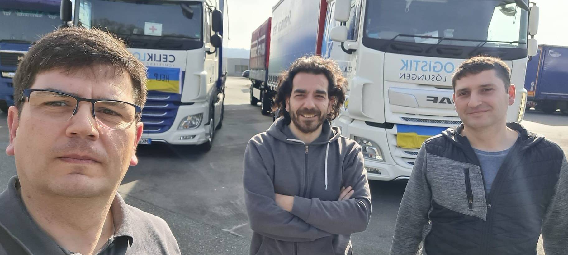 Mustafa Celik mit Mitarbeiter Samuel und dessen Bruder Benjamin vor den LKW