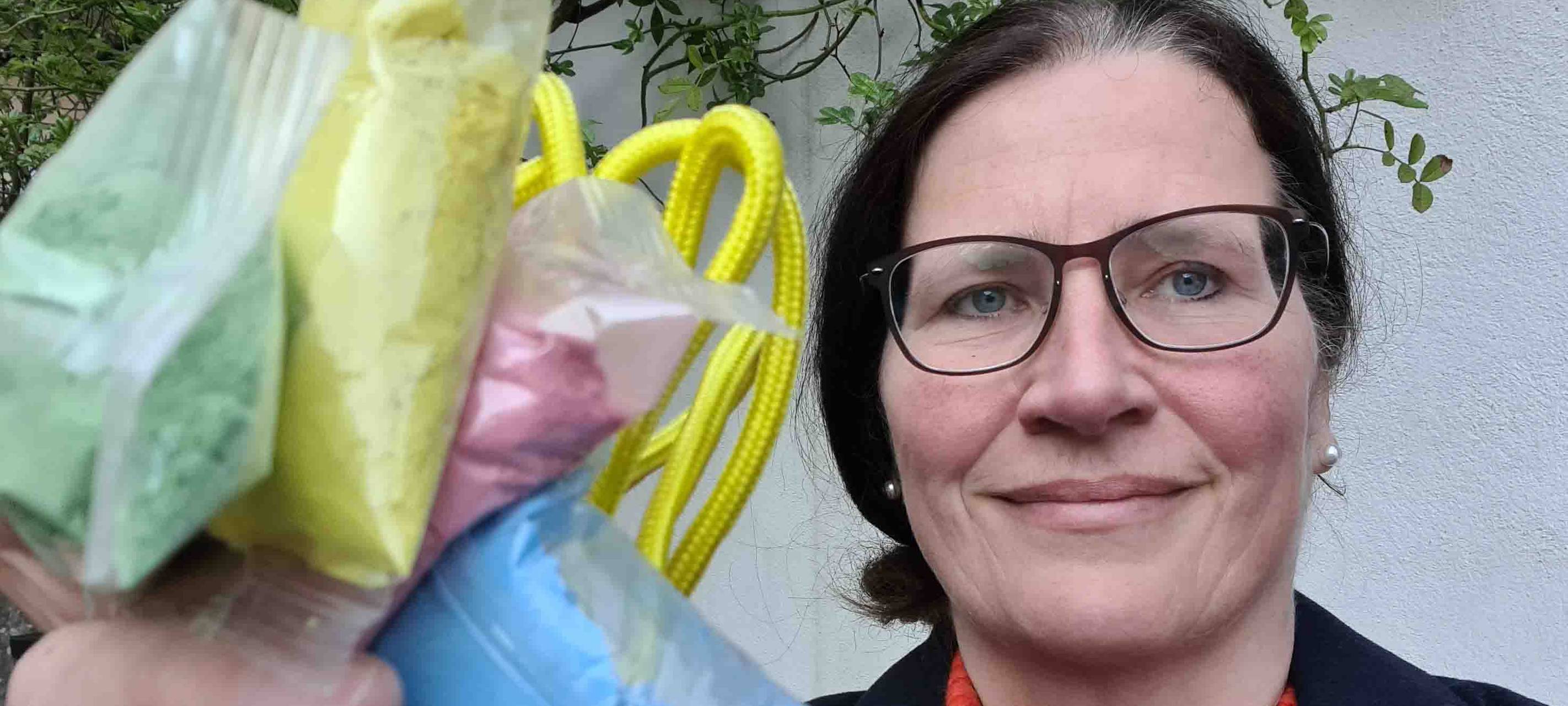 Eine Frau hält Springseil und Farben hoch