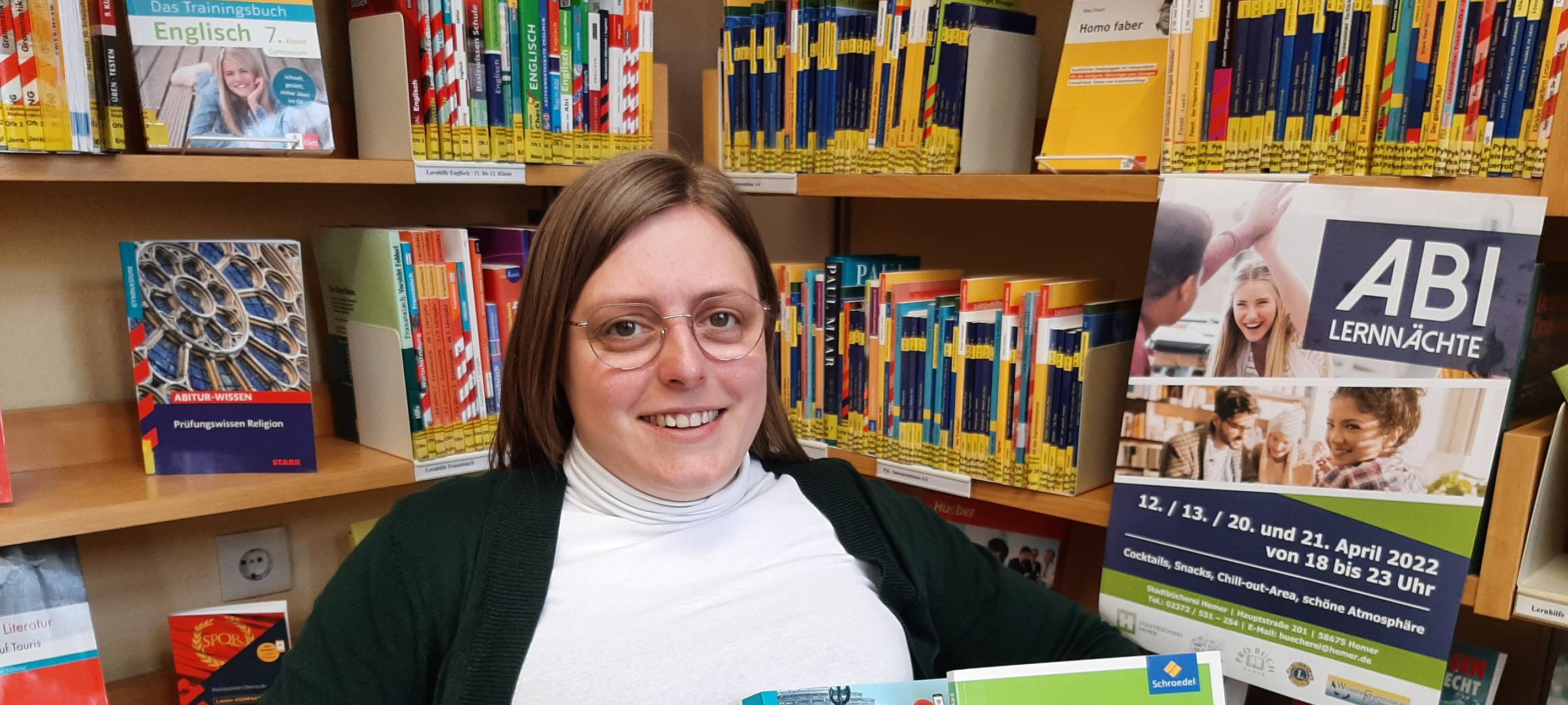 Frau mit Brille in der Stadtbücherei vor einem Bücherregal