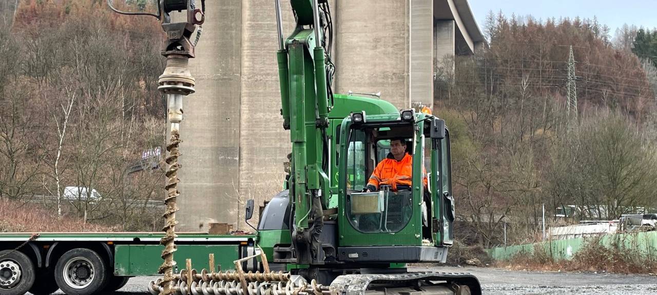 Bagger mit Fahrer vor der Rahmedetalbrücke bei den Sondierungsarbeiten.