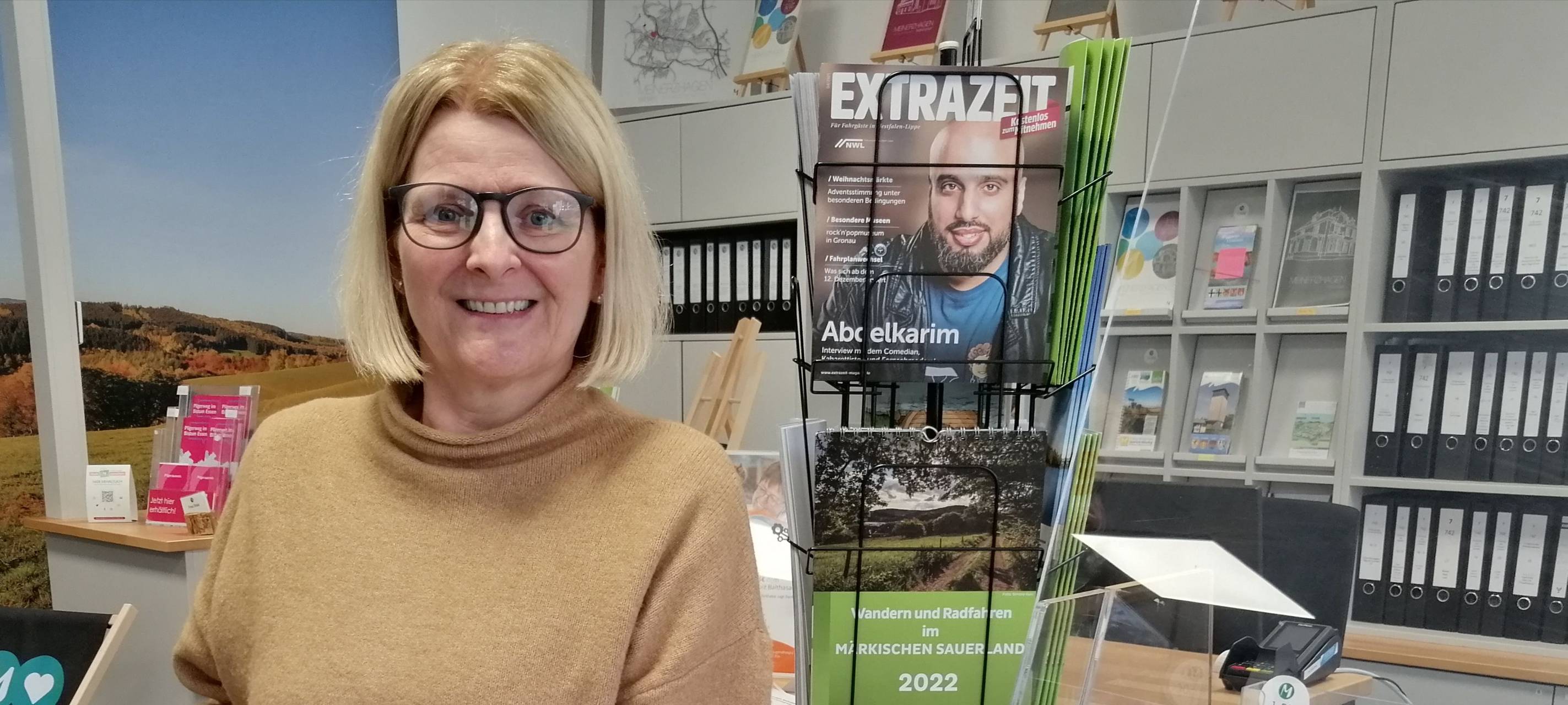 Eine Frau hält das Kochbuch nach vorne