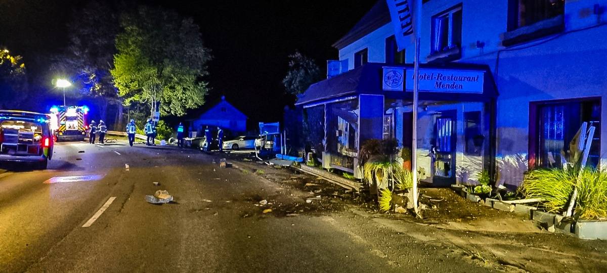 Unnaer Straße. Rechts: das demolierte Vordach des Hotel-Restaurants Menden. Davor Schmauchspuren und Einsatzwagen und Einsatzkräfte der Feuerwehr.
