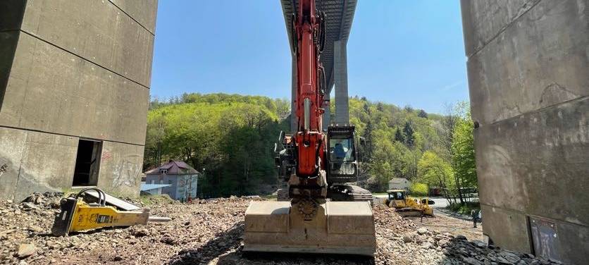 Ein Bagger steht unter der A45 Rahmedetalbrücke.