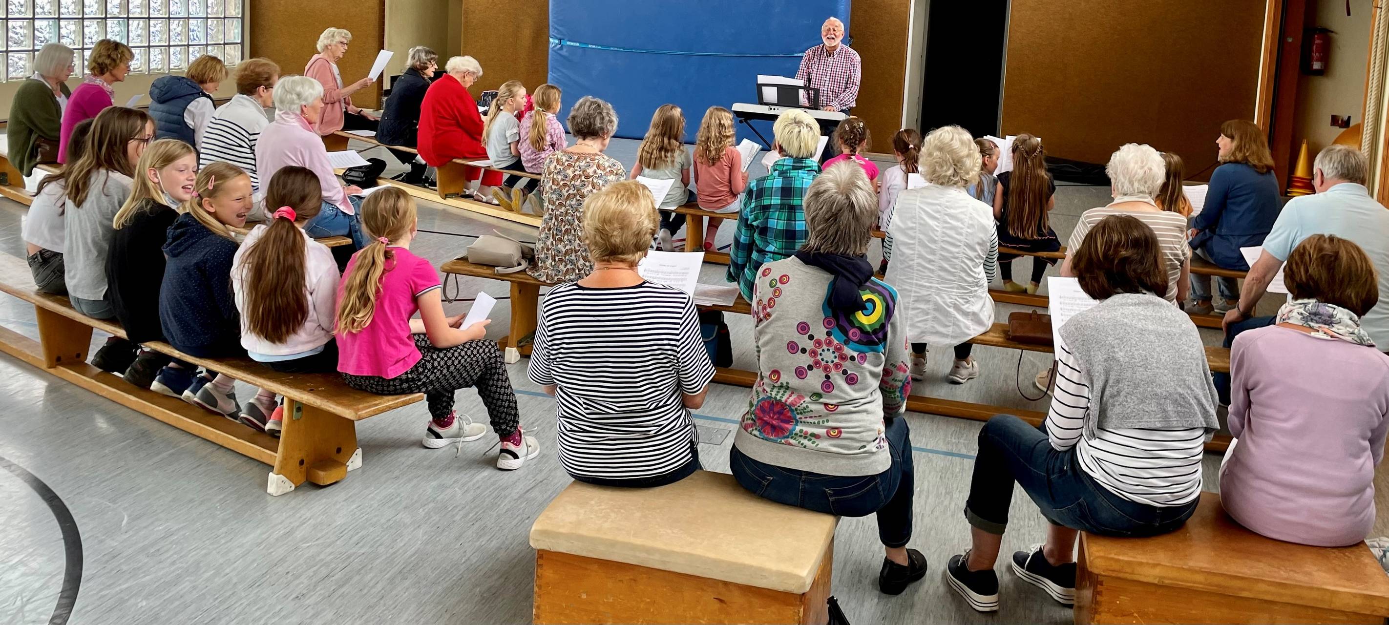 Kinder und Großeltern sitzen zusammen und proben