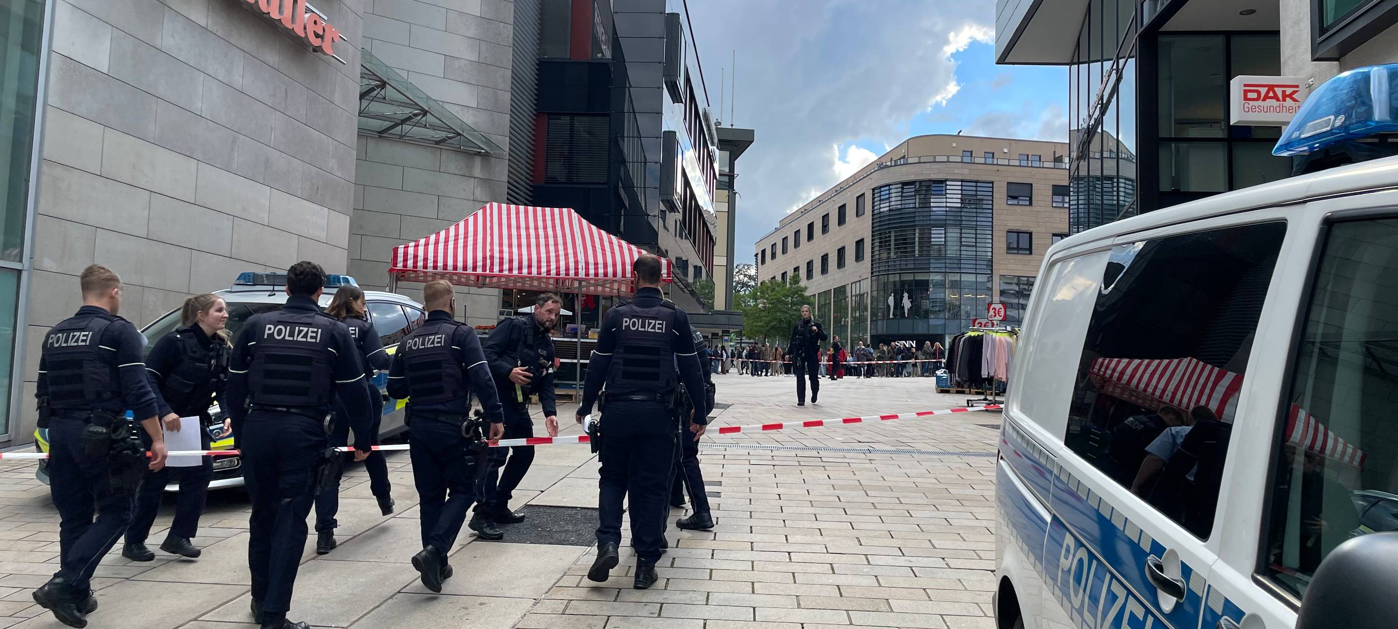 Abgesperrter Bereich, Polizisten stehen am Auto