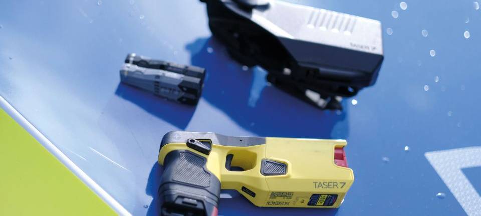 Taser der Polizei liegen auf Polizeiauto