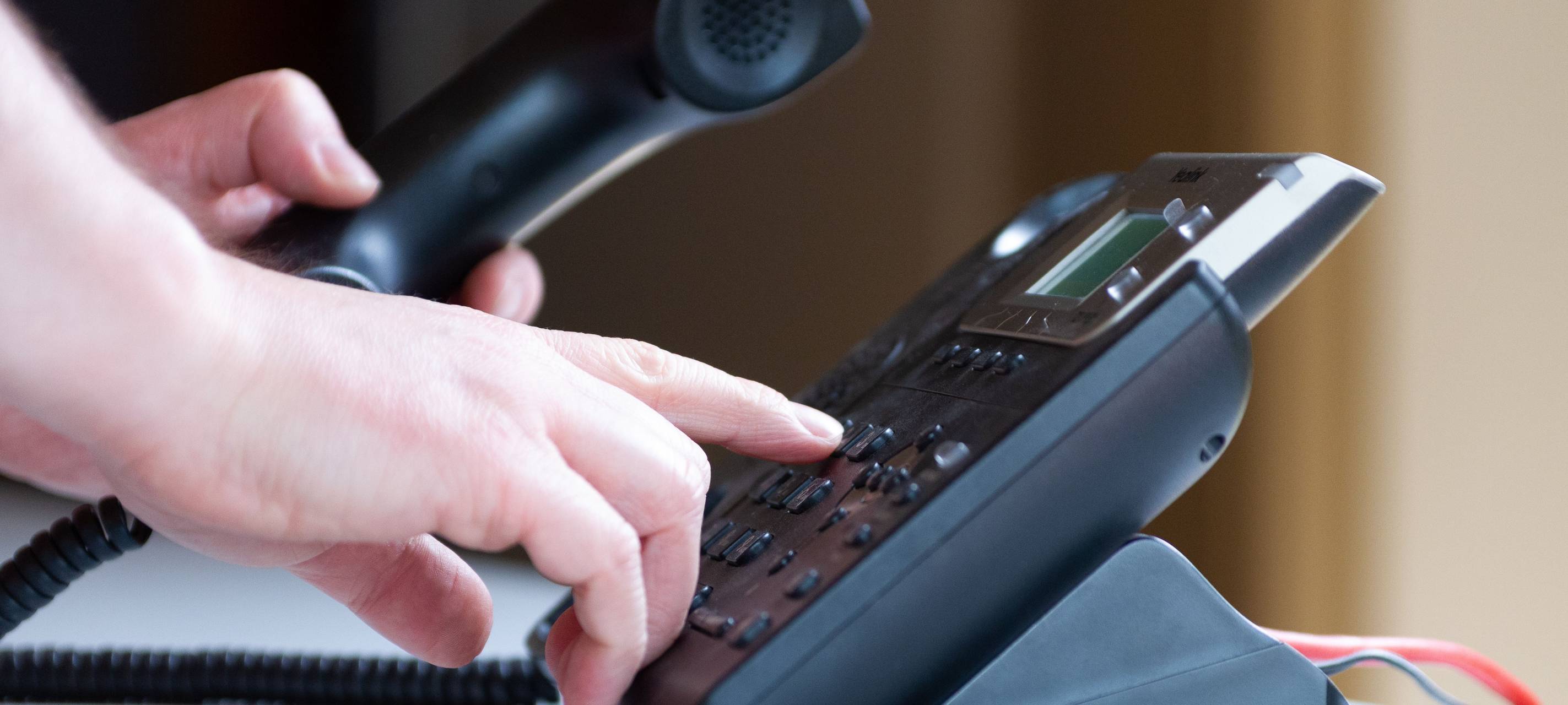 Person tippt Tasten auf Telefon