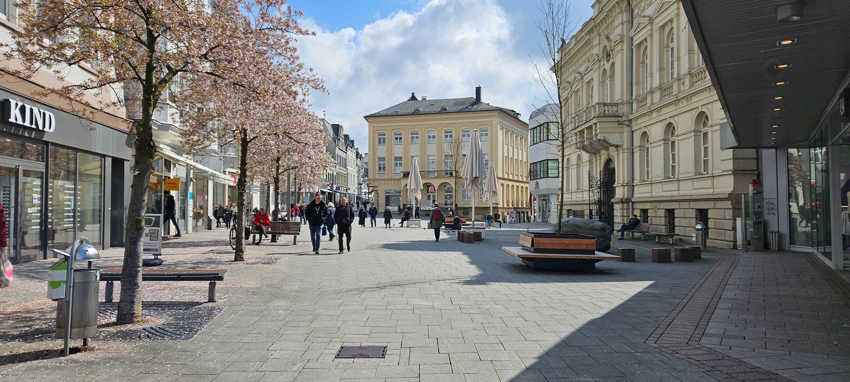 Die Iserlohner Innenstadt. Links und Rechts sind Läden, in der Mitte ein Platz mit Bänken.