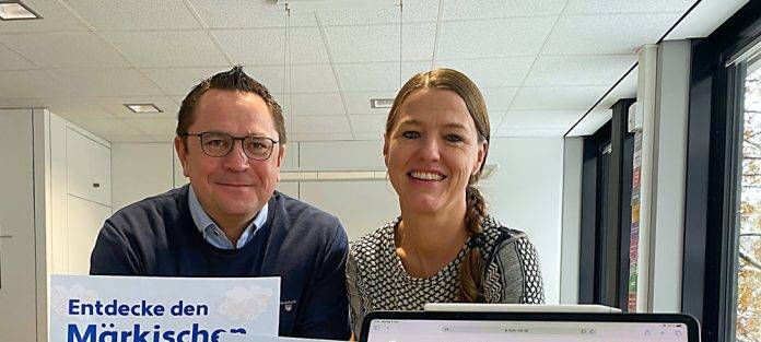 Marco Voge und Alexandra Hübenthal zeigen auf einem Laptop die neue Homepage.