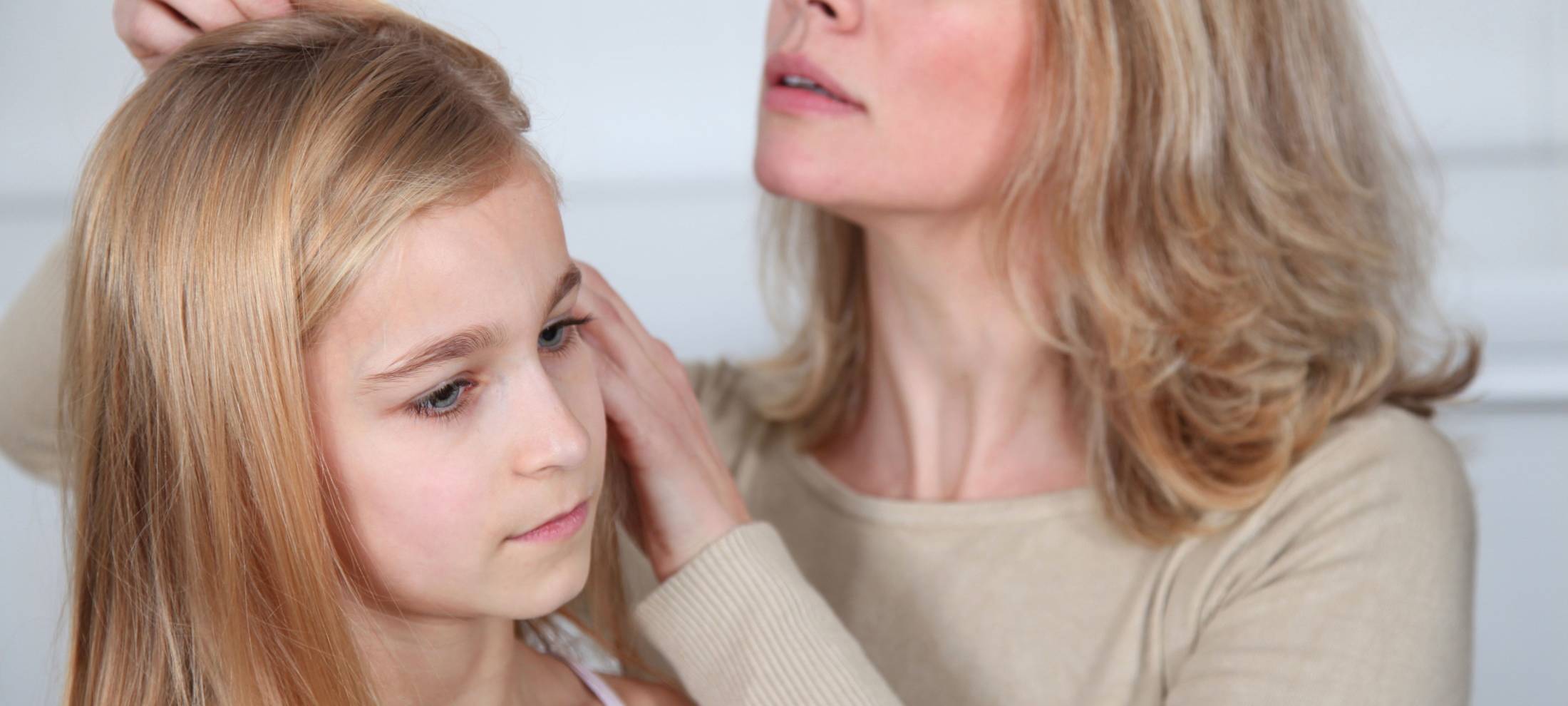 Mutter untersucht Tochter auf Kopfläuse