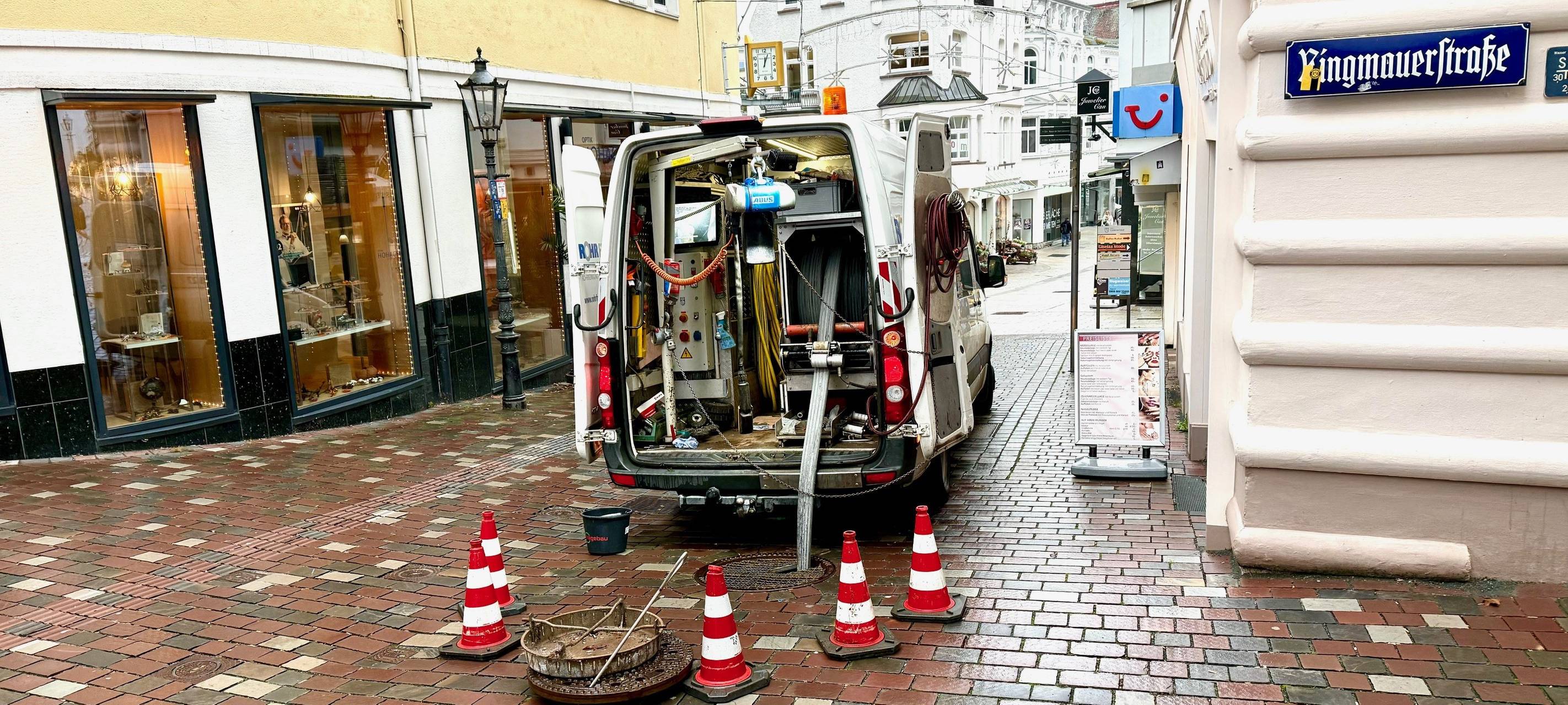 Absperrhütchen sichern einen geöffneten Gully-Deckel.