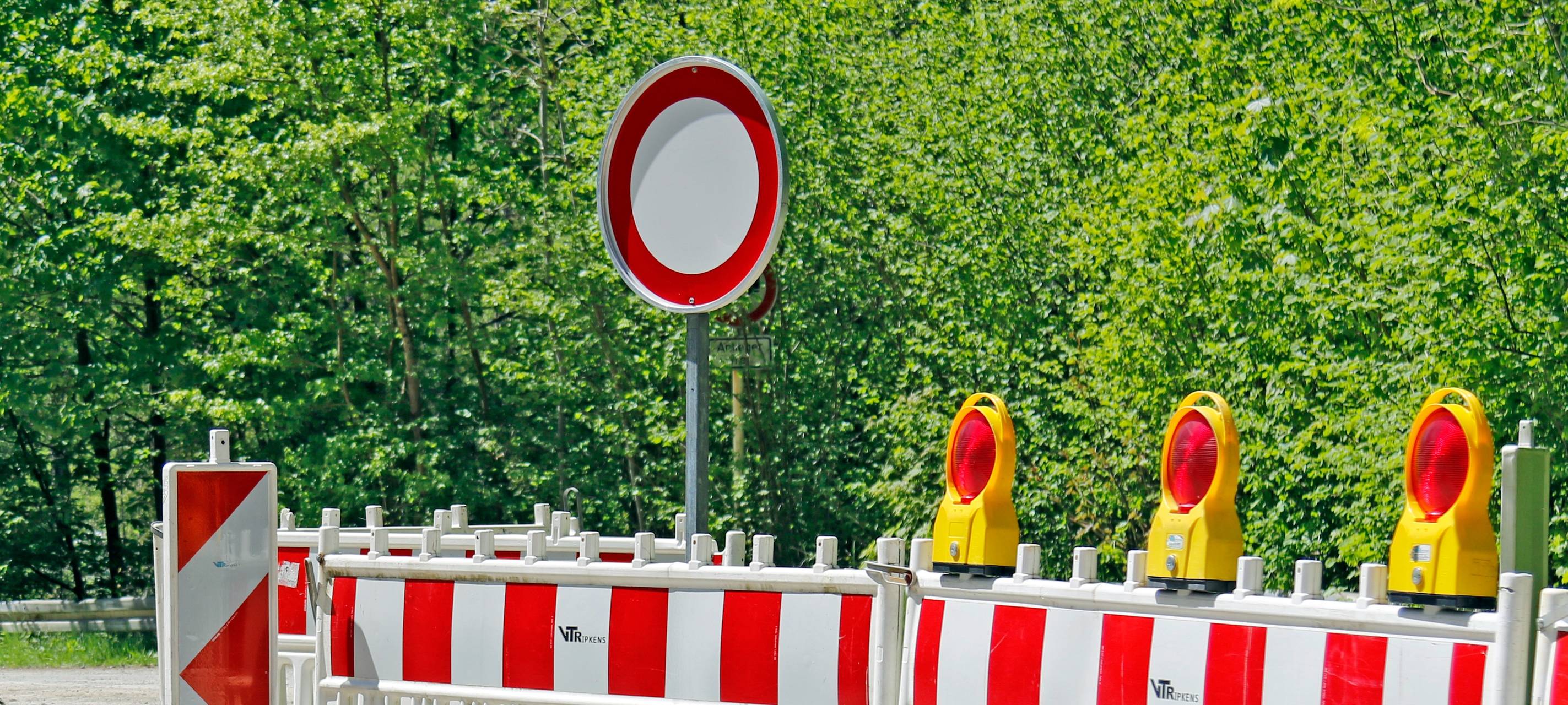 Baustellenabsperrungen vor einer Straße.