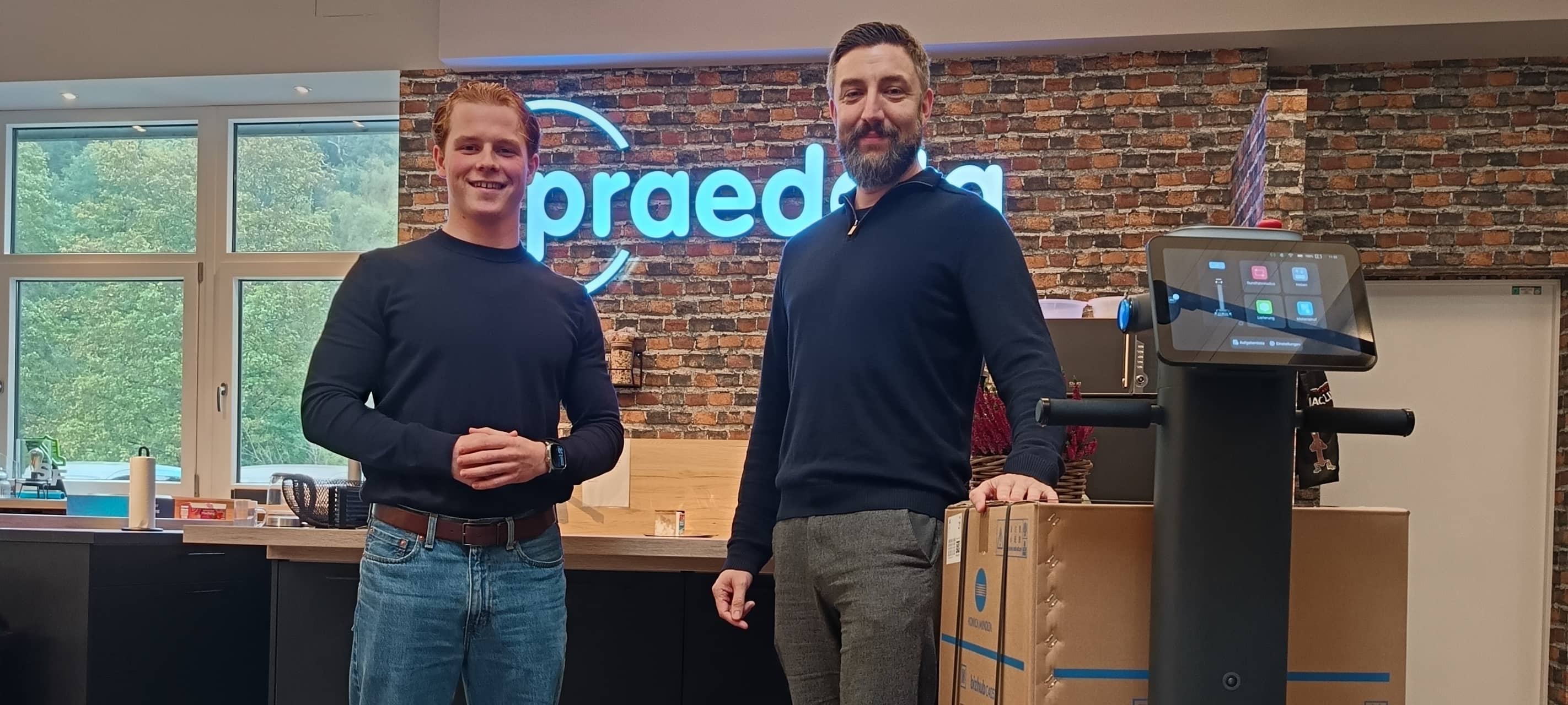 Valentin Goerlich (l.) und Robotics-Leiter David Schulz von Praedata aus Nachrodt-Wiblingwerde zeigen, was ihre Roboter draufhaben - Putzen und Schleppen inklusive.